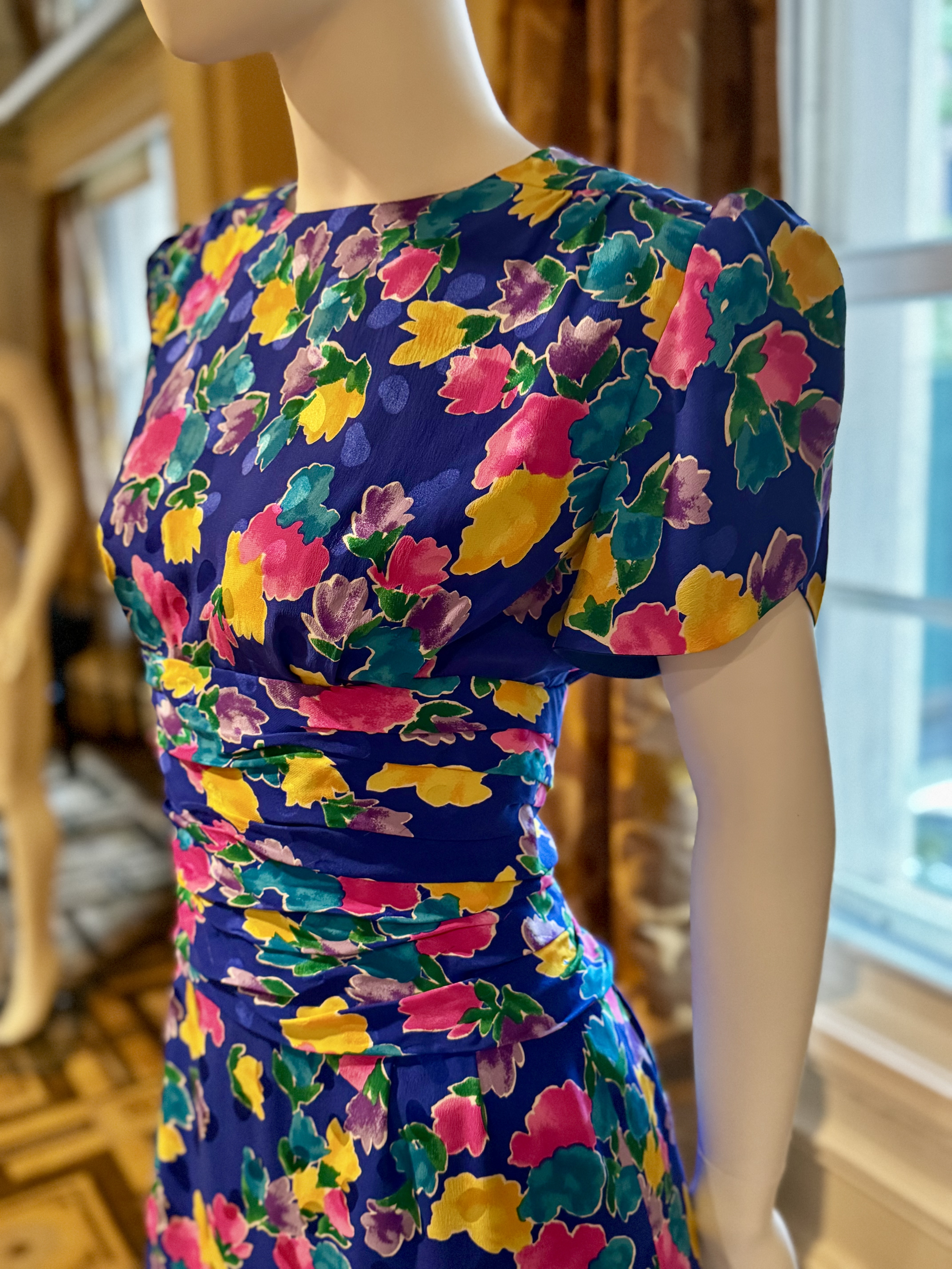 A photo of Princess Diana's blue floral Caring Dress on a mannequin