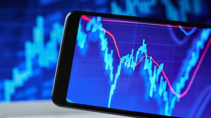 blue stock market chart with red moving average on smartphone and in background