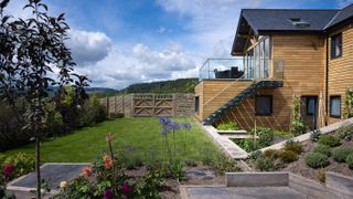 new contemporary house with sloping garden surrounded by fencing