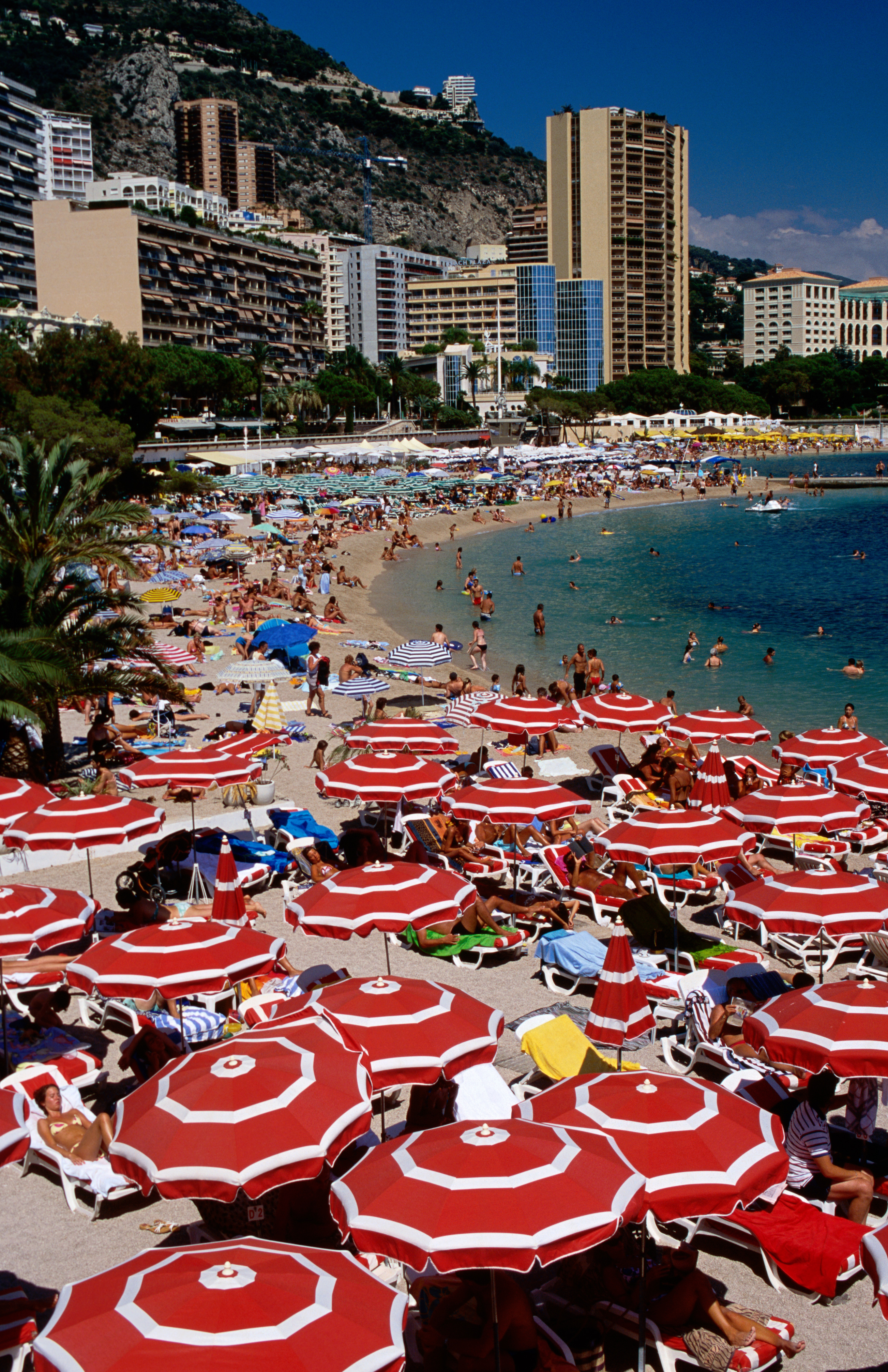 Red and white stripe umbrellas on Larvotto Beach