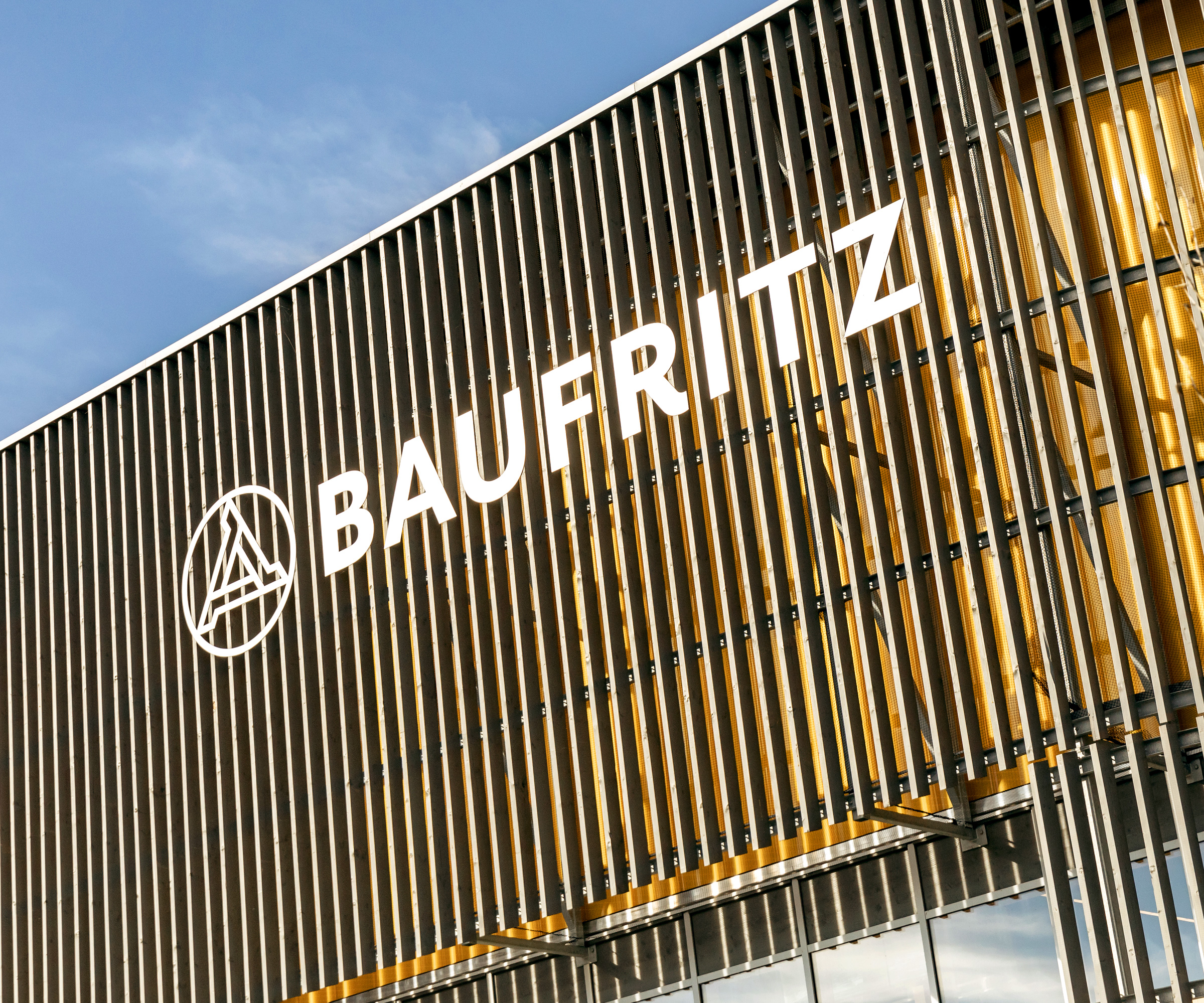 Outside of Baufritz timber facade design centre with Baufritz logo