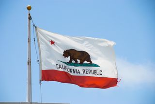 Low angle view of California flag against a clear sky