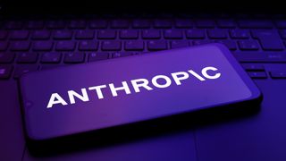 Anthropic logo pictured on a smartphone placed on a computer keyboard.