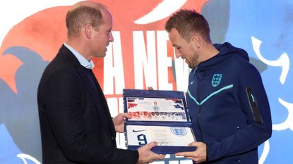 Prince William, Prince of Wales presents an England shirt to Harry Kane of England at St George's Park on November 14, 2022 in Burton upon Trent, England.