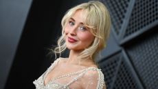 a young blonde woman taking photos on the grammys red carpet