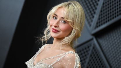 a young blonde woman taking photos on the grammys red carpet