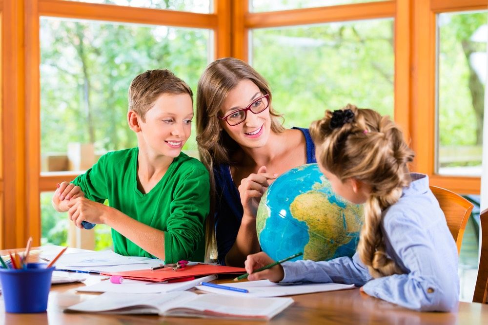 Homeschooling mother teaching kids private lessons in geography