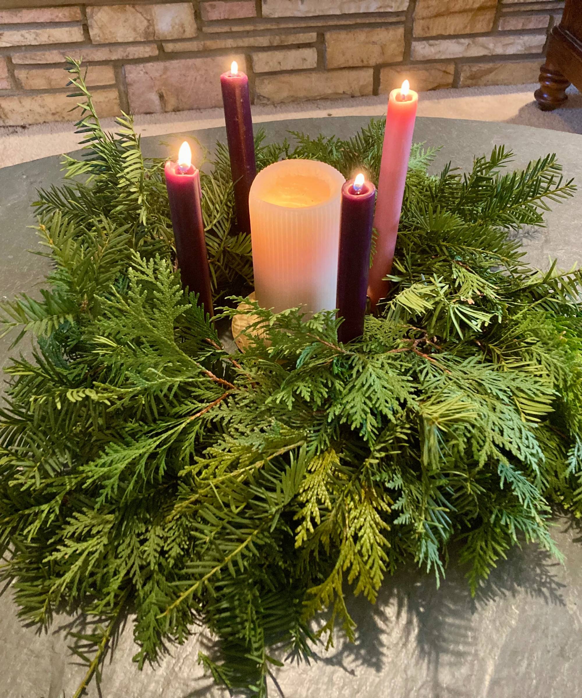 Light candles inside an evergreen Advent wreath
