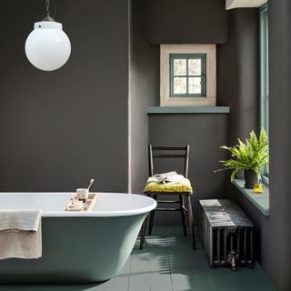 Dark bathroom with standalone bath tub