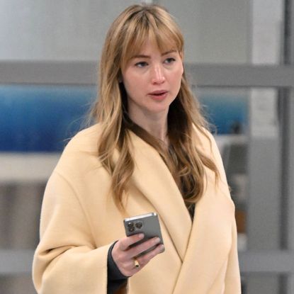 Jennifer Lawrence landed in JFK Airport wearing a The Row coat, a Dior Book Tote, and a Tumi suitcase