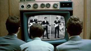 Several young men watching musicians in TV in the early 1960s