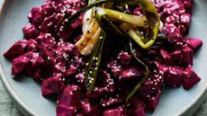 Bowl of chopped beetroot with charred spring onions and sesame seeds