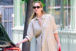 Jennifer Lawrence wearing a button-down shirt and sunglasses.