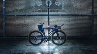 A purple time trial bike stands in a warehouse setting