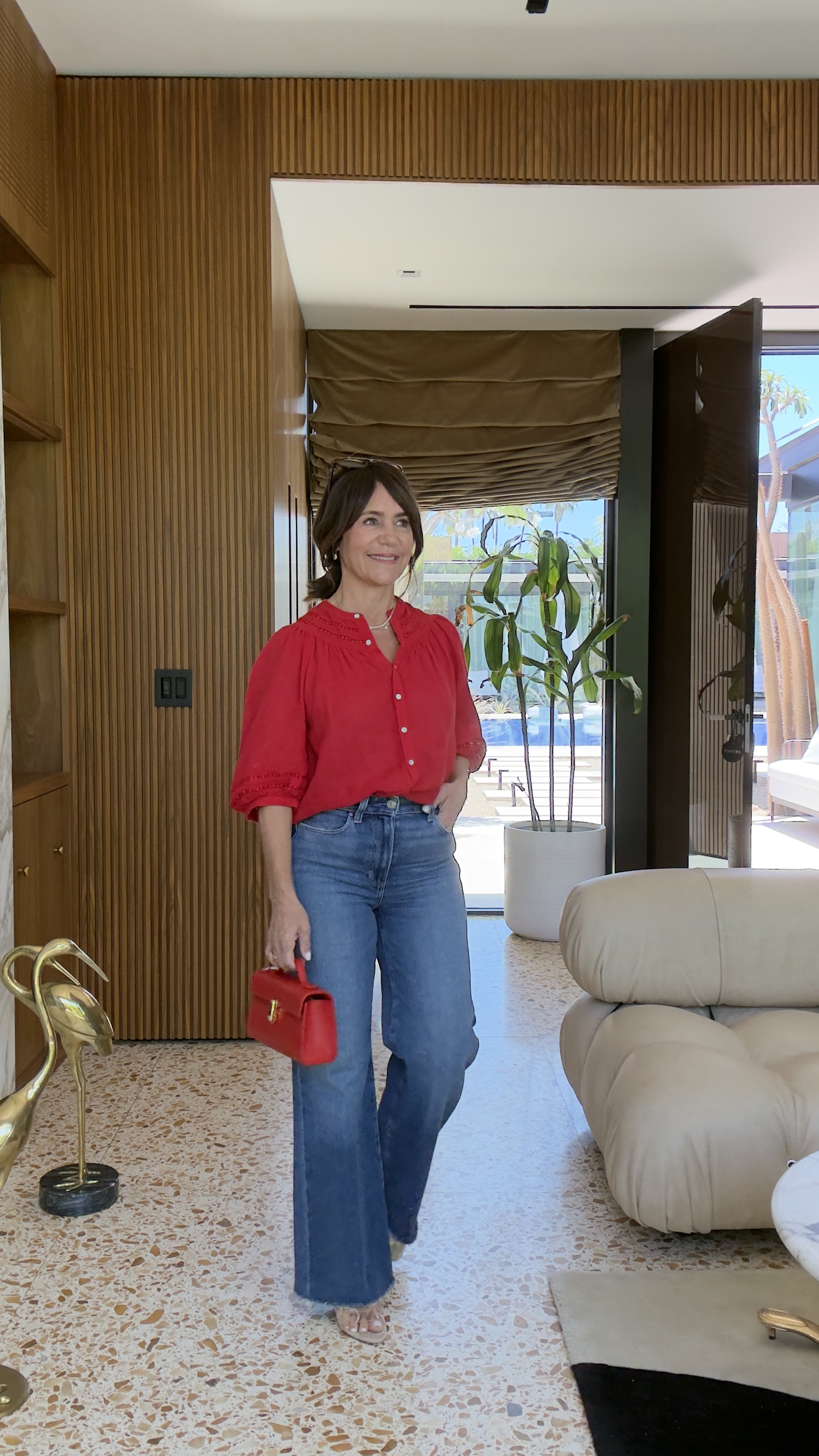 Susie Wright wearing flared jeans and a red button-down.