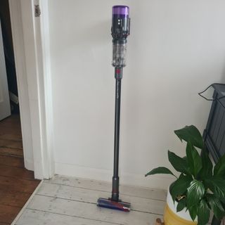 Dyson Micro 1.5kg standing against a wall