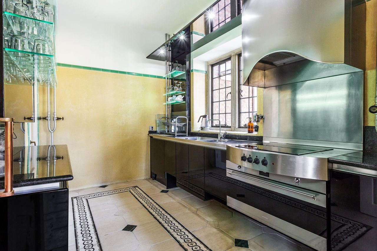 A kitchen stove with silver splashback and glass glass holders
