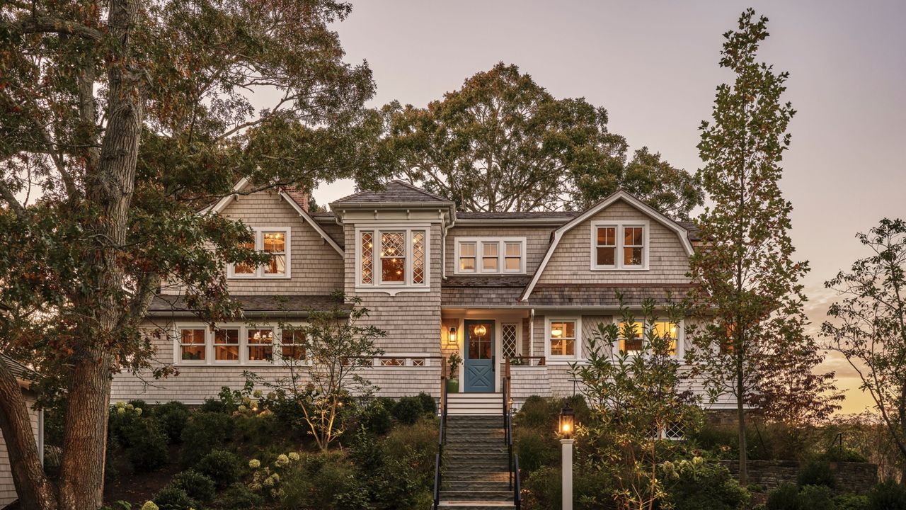 cape cod house exterior with trees around and sunset