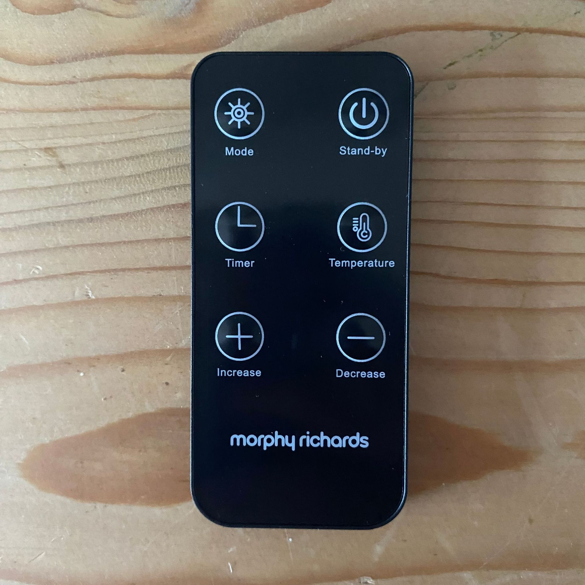 Remote control of the Morphy Richards HeatFlux 2.5kW Digital Oil-filled Radiator on a wood surface