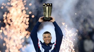 Kylian Mbappe holds a trophy aloft in a ceremony after PSG's 4-2 win over Nantes, in which he became the club's all-time top scorer with 201 goals.