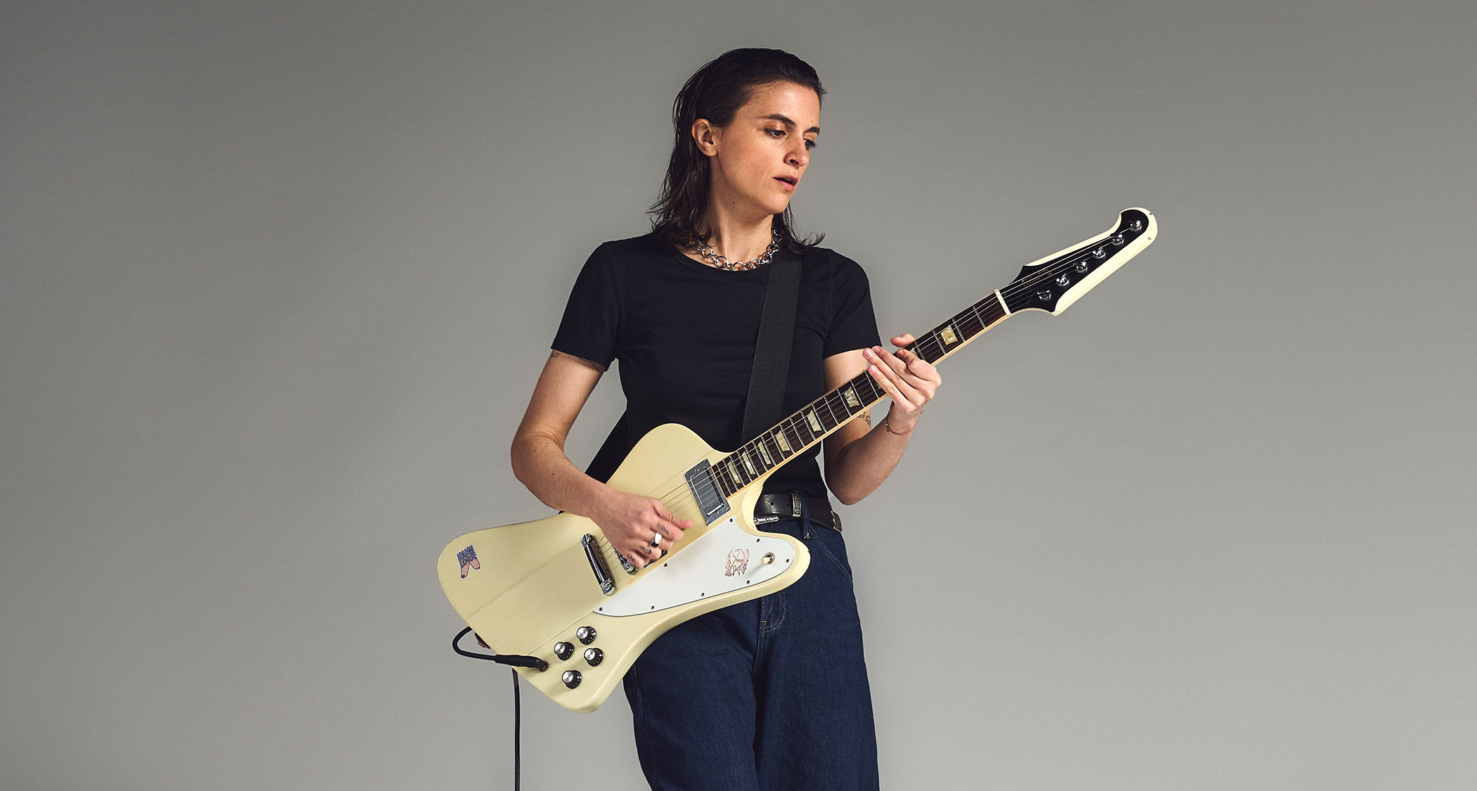 Laura Cox photographed with her white Gibson Firebird