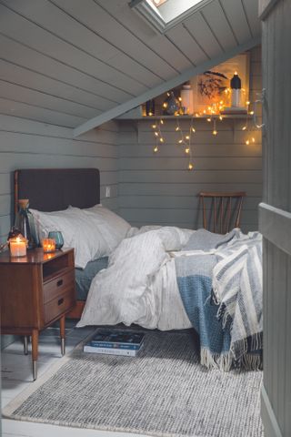 white and gray Scandinavian style bedroom by Soak & Sleep, with fairy lights on a shelf