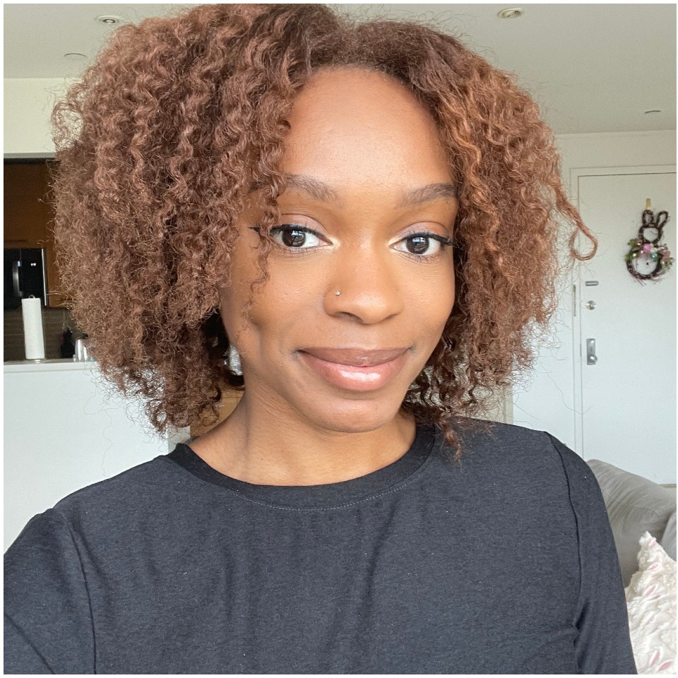 a woman with light brown hair wearing a black shirt