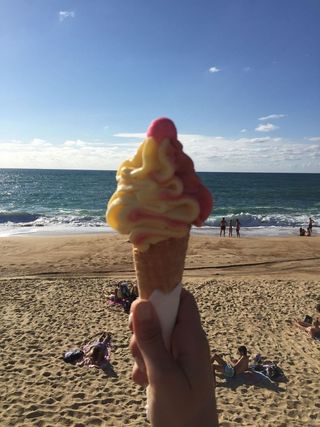 Charlotte holding an ice cream on a cone on the beach