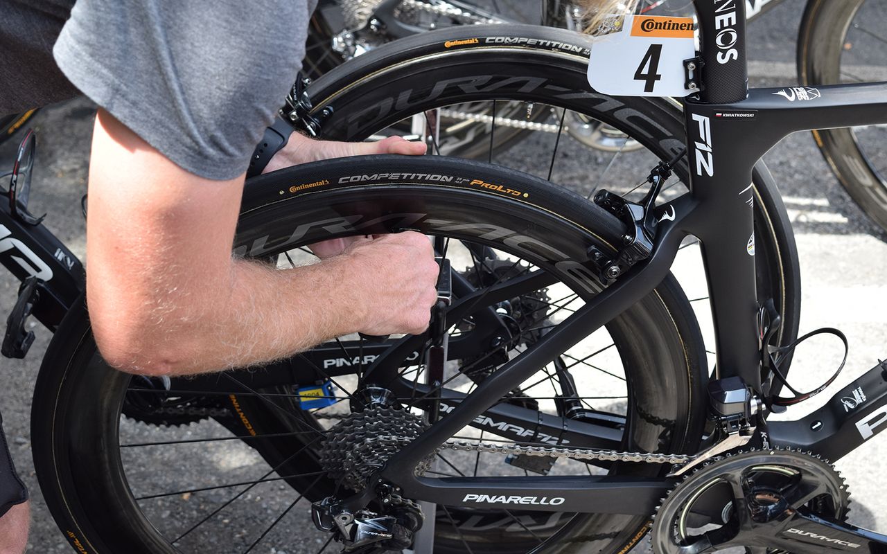 A Team Ineos mechanic checks each rider's tyre pressures with a digital gauge ahead of each stage