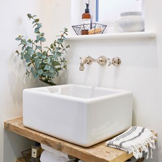 bathroom with white wash basin wooden shelves