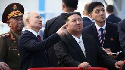 Russian President Vladimir Putin points out something to North Korean leader Kim Jong Un