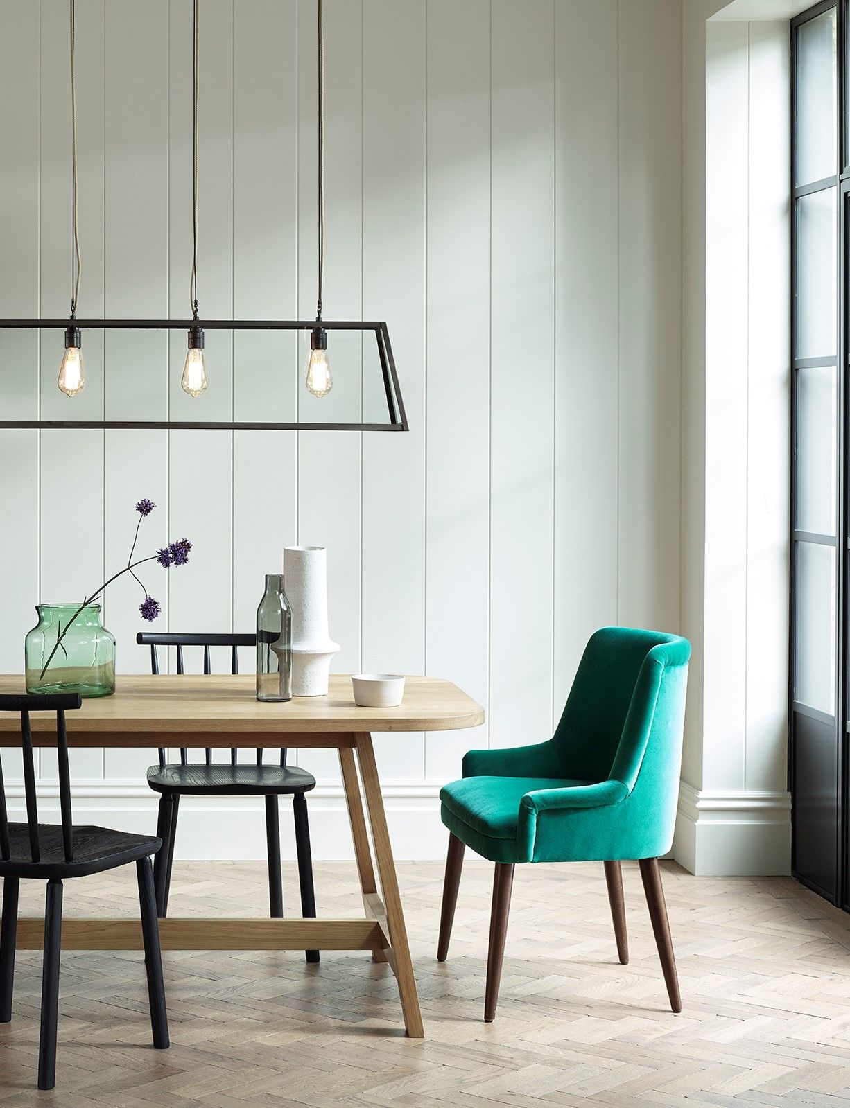 white dining room with rectangular table and chairs, with green accents 