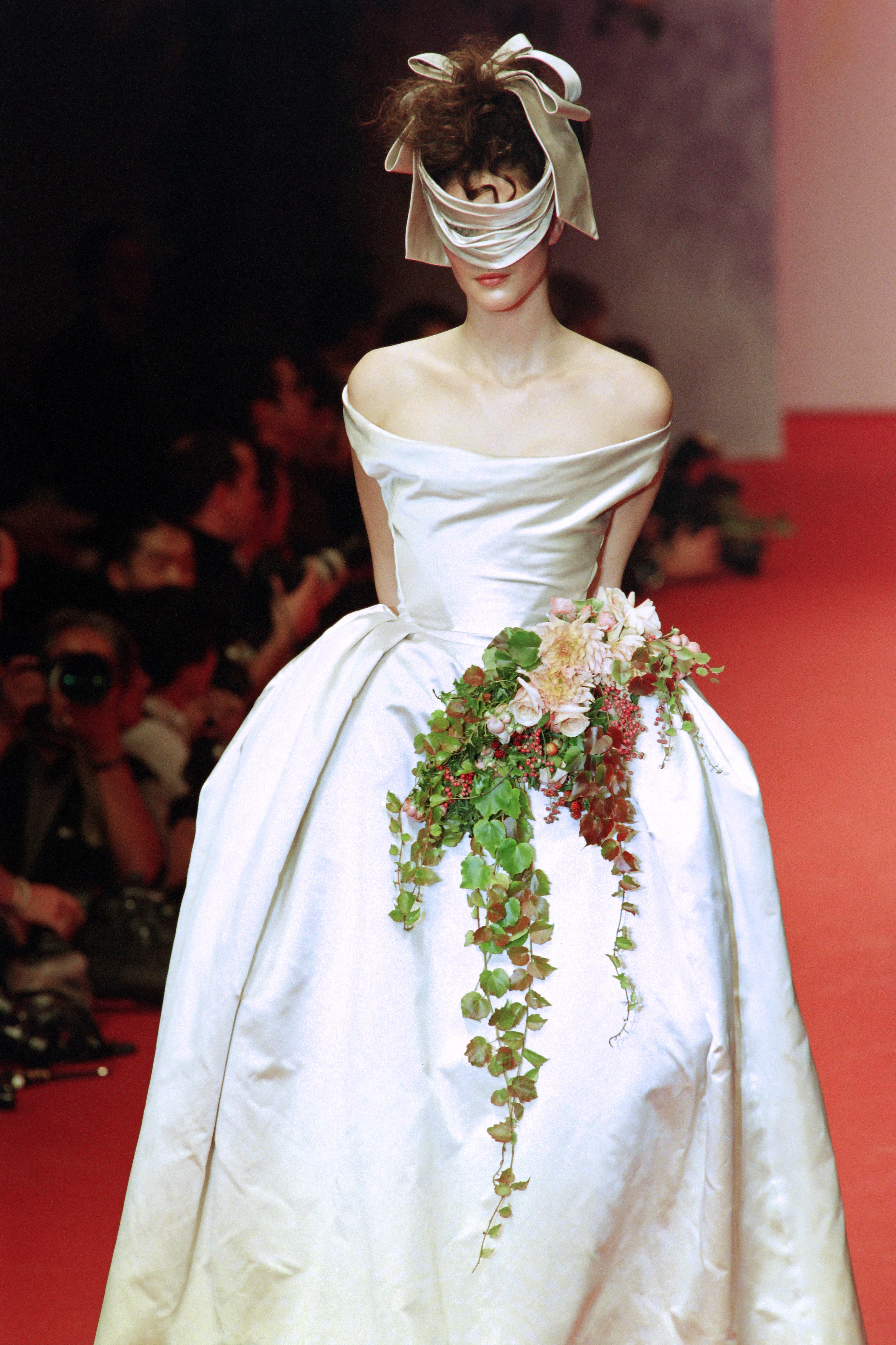 a woman wears a strapless dress with flowers.