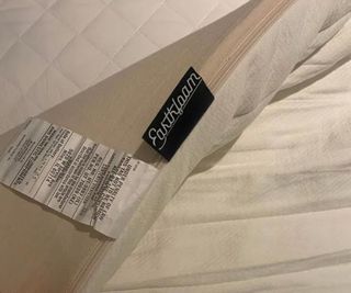 The corner of the Earthfoam Mattress Topper over a mattress protector.