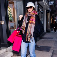 Katie Holmes shopping while wearing a colorful plaid scarf with a white beanie and blue jeans