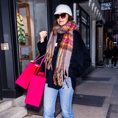 Katie Holmes shopping while wearing a colorful plaid scarf with a white beanie and blue jeans