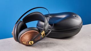 the meze 99 classics 2nd gen headphones with walnut finishes and gold touches against the blue tom's guide background