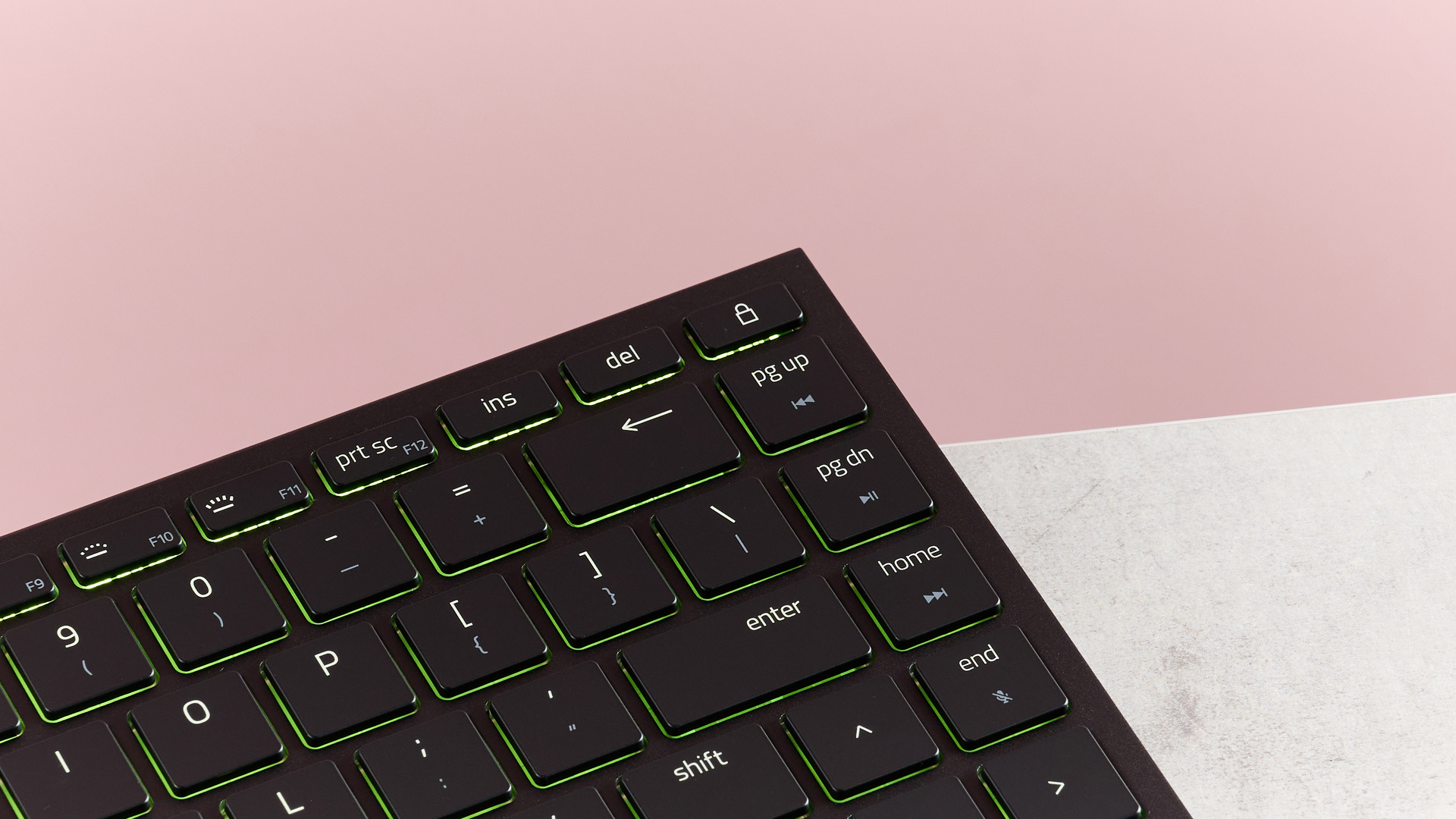 Close-up of right corner of Razer Joro on desk with pink background