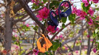 The orange Powerbeats Pro 2 next to the Navy original Powerbeats Pro.