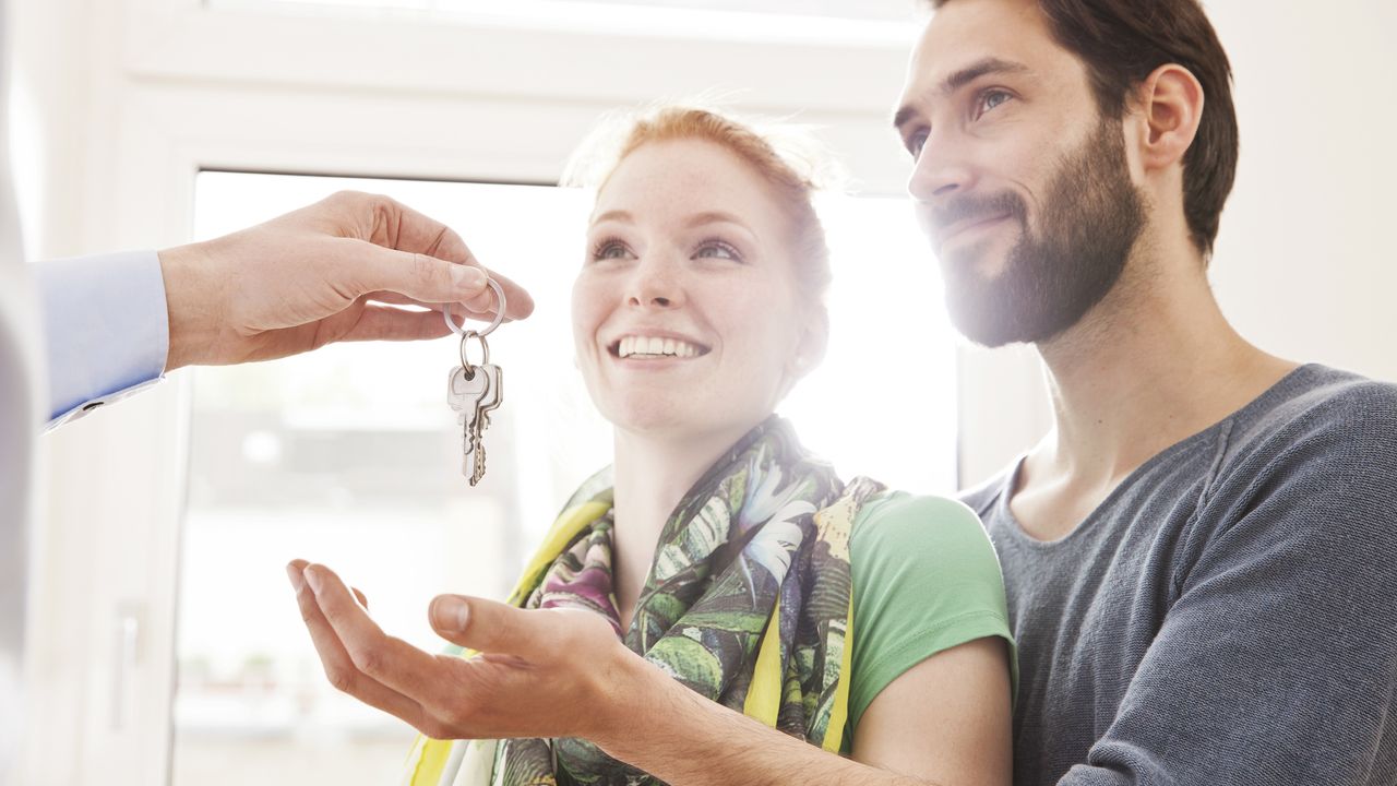 young couple being handed the keys to their new home