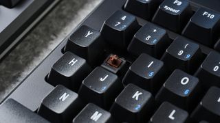 A removed keycap showing the Cherry MX Brown mechanical switches on a Kinesis Freestyle Pro