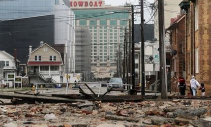 People walk past debris on Oct. 30 where a 2,000-foot section of the Atlantic City, N.J., boardwalk was destroyed by flooding from Hurricane Sandy.