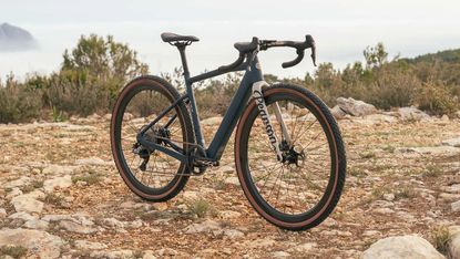 The Pearson On&Off GRX 820 electric gravel bike side on with gravel back drop