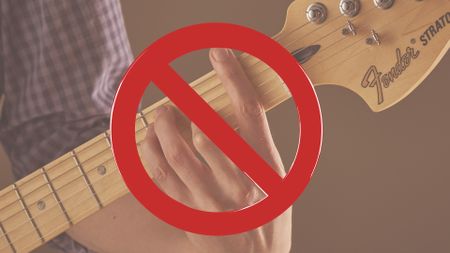 Close-up of fretting hand playing F barre chord with banned sign overlayed