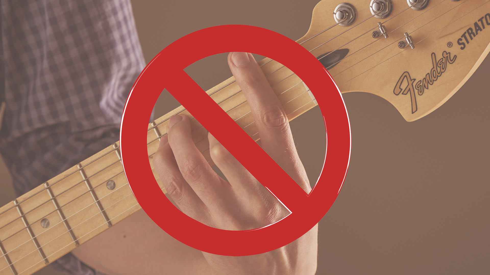 Close-up of fretting hand playing F barre chord with banned sign overlayed