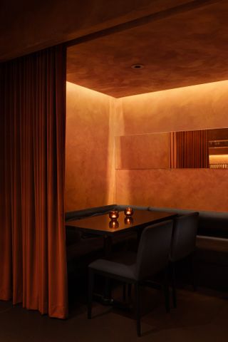 Private dining area at Ama Bar, hidden by a velvet orange curtain