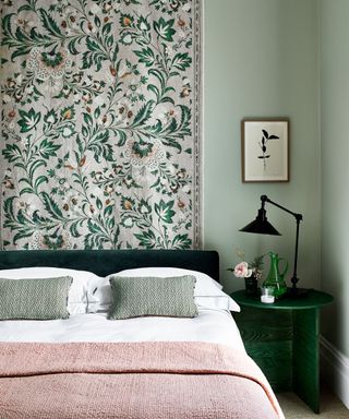 green bedroom with patterned fabric wallhanging