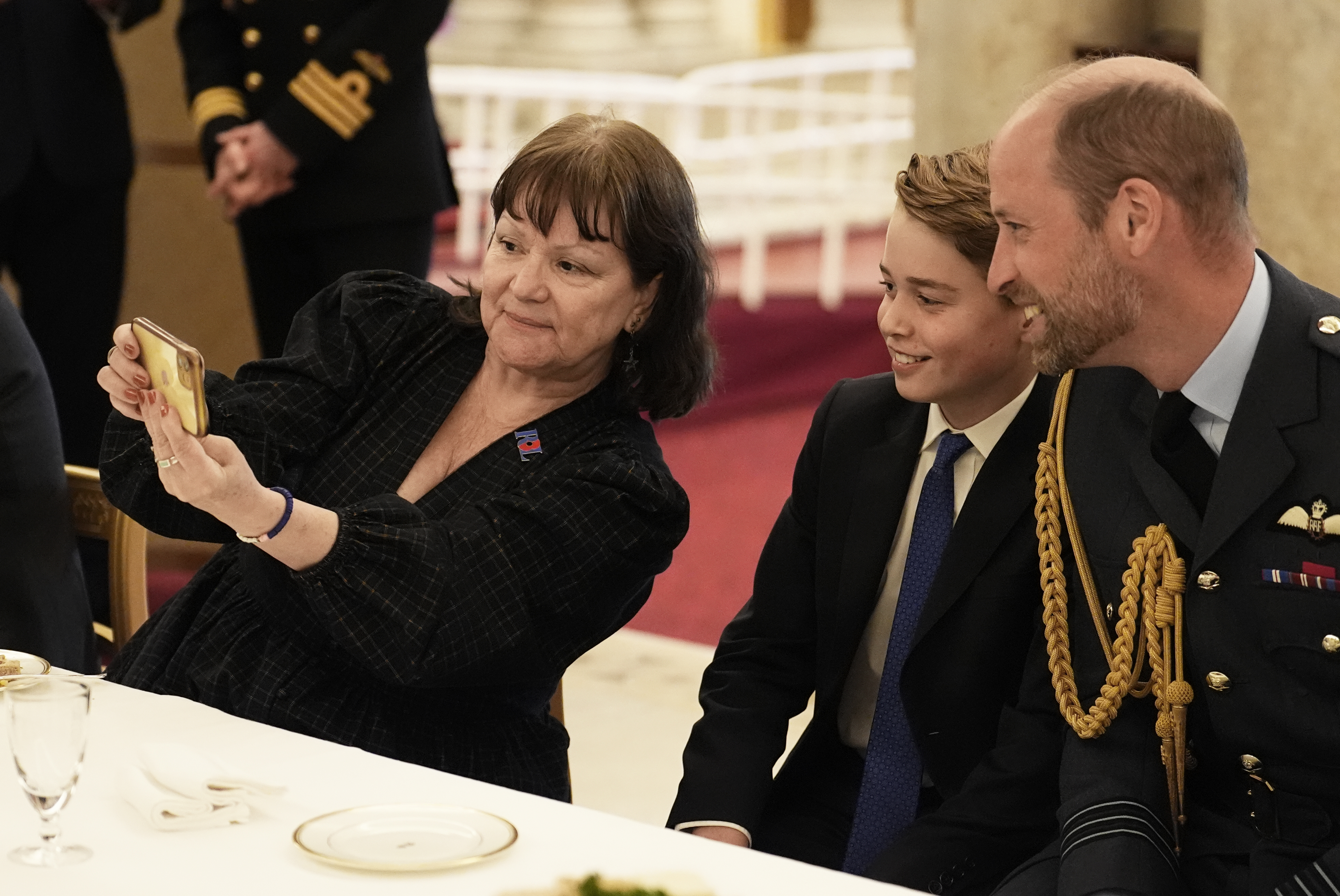 Prince George and Prince William taking a selfie with a woman at a VE Day party