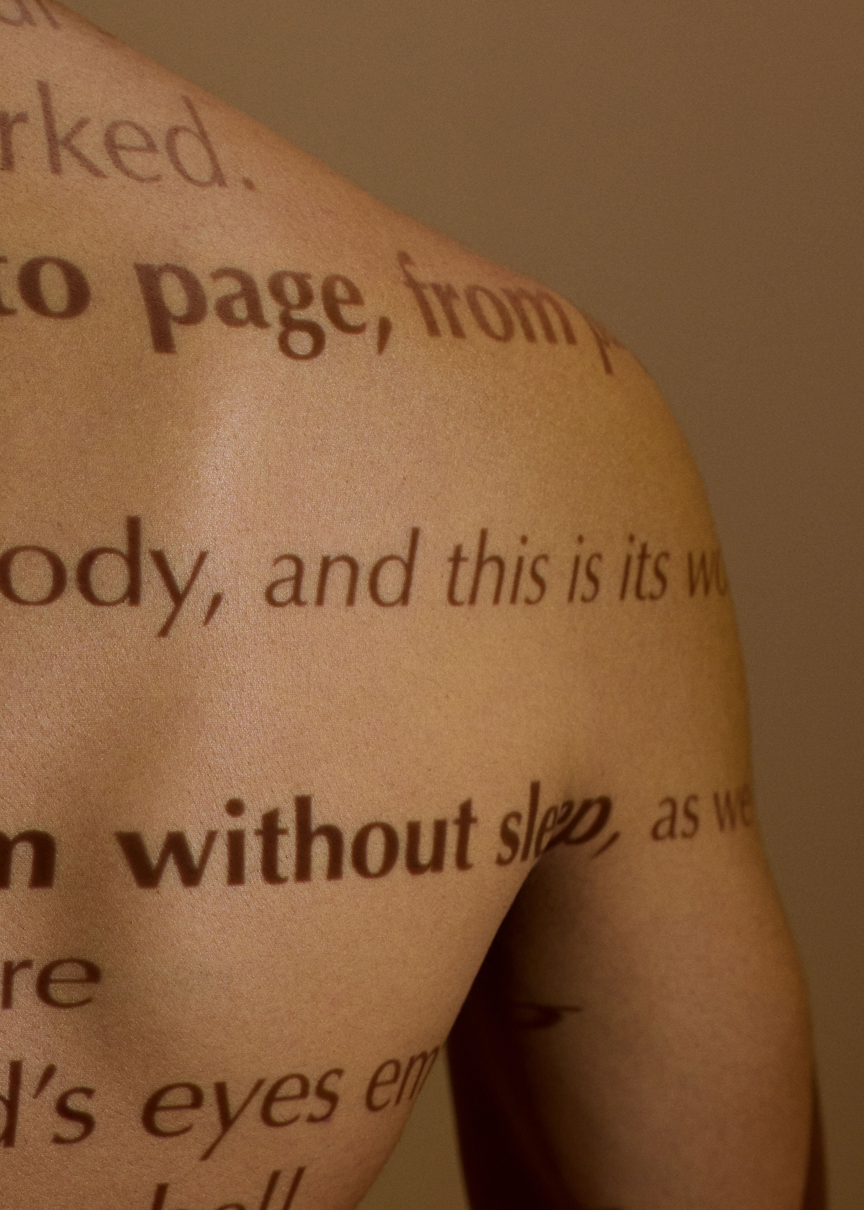 an image of words from a queer poem projected onto a person's back