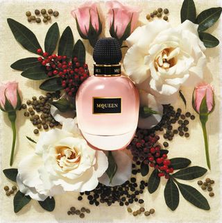 McQueen Celtic Rose perfume in pink bottle surrounded by flowers and leaves